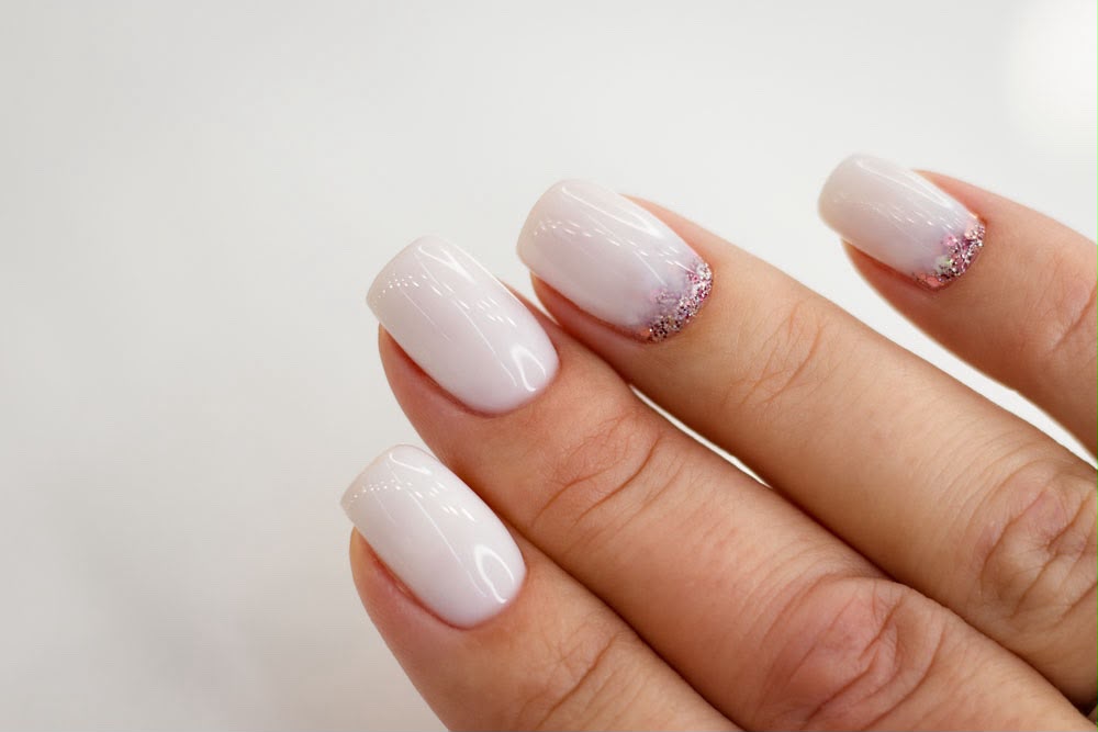 Nude negle med glitterdetalje ved neglerod